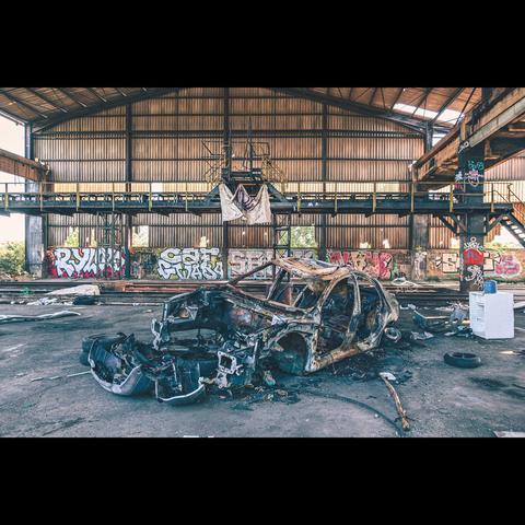 old burnt car in an abandoned factory, france