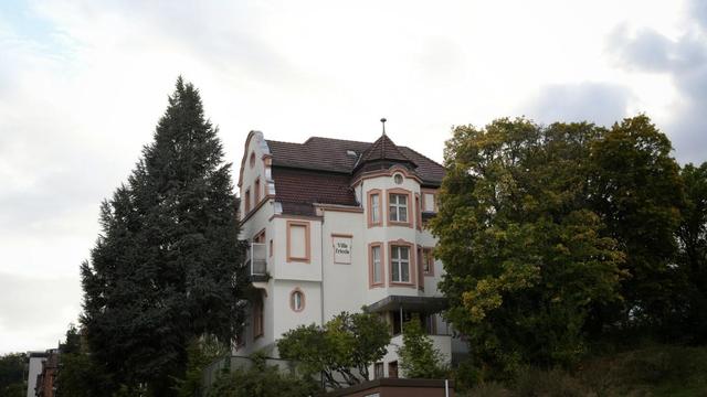 Villa from about 1900 on a little hill 
painted white with antique pink window frames
