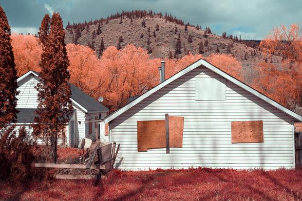 A boarded-up home on the banks of the river.