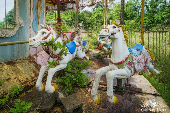 carousel that is overgrown, focus on 2 horses