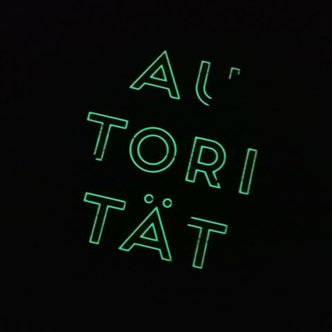 Ein dunkles Foto. Die Umrisse von Buchstaben sind zu sehen: AUTORITÄT.