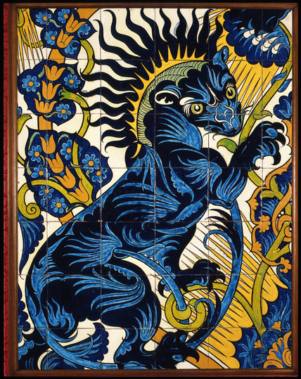 “This tile panel was designed by William De Morgan, the leading ceramicist of the Arts and Crafts movement. The panel is made up of 42 tiles and depicts a rearing lion painted in bold enamel colours. The lion is highly stylised with a large clawed paws and a sun-ray mane. The design demonstrates De Morgan’s admiration for Iranian and Ottoman Iznik tiles. The panel (and another see C6a) was donated by H.C.Mossop, who’s sister Nellie Mossop painted tiles and other ceramics for De Morgan in the early years, when he was working at Orange House in Cheyne Walk. This tile panel was made after that period, at Sands End, Fulham, when De Morgan was in partnership with the architect Halsey Ricardo. An identical panel, with the design reversed and in different colours is also in the Gallery’s collection (see C6a).”