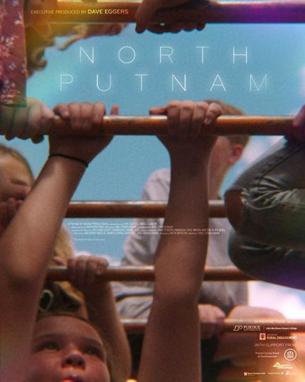 Detail from the official film poster for North Putnam. Elementary school students hang from monkey bars beneath a blue sky. The film title is in thin white letters across the top.