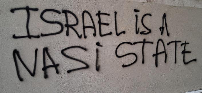 sur un mur gris en capitales noires au spray caption= Israel is a nazi state