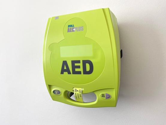 Gelbgrüner Defi hängt an einer weißen Wand.