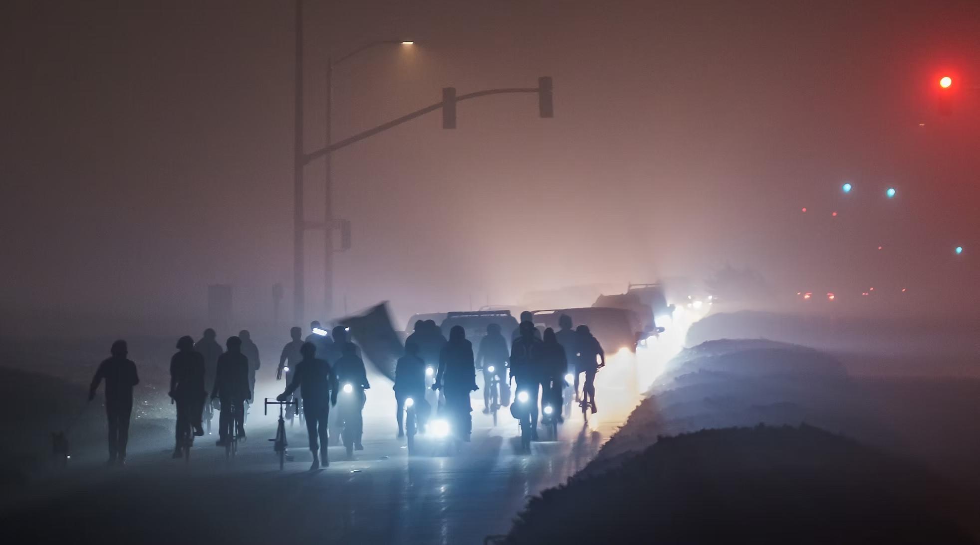 Group of people on bikes and runners in front of cars on the Great Highway at night. Credit to Open The Great Highway