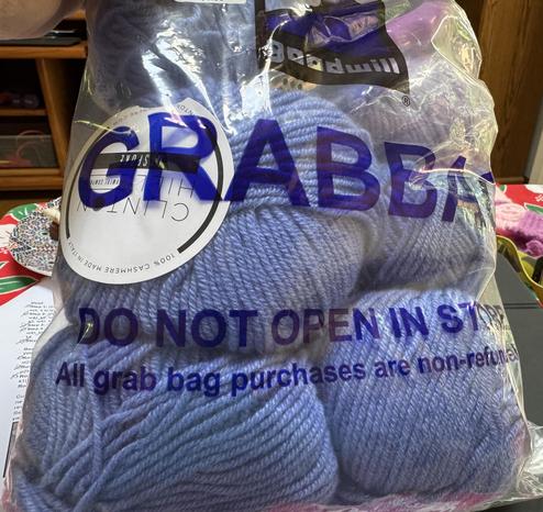 The picture shows a clear plastic bag from Goodwill, labeled "Grab bag." It contains multiple 100 gm balls of french blue yarn, worsted (or medium) weight. They are from the Clinton Hill company, are 100% cashmere and the line is called BESPOKE. There is something pink in the upper right hand corner of the bag--it turned out to be a paper puncher with a pink handle. Goodwill often puts weird things together in these grab bags, and they usually sell for $5.99 each. I almost bought a bag that had two dozen unopened bottles of nail polish (and some toothbrushes), but I only needed one bottle and what would I do with the rest?