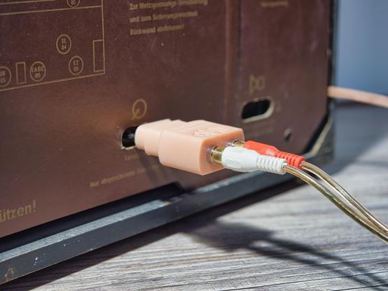 NF TA Stereo Stecker mit angeschlossenen Cinch Kabeln an der Rückwand eines Röhrenradios.