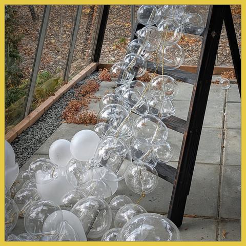 Installation 'path of life' - a black kitchenstair with white and transperent glassbowls, tied to each other with a golden thread.