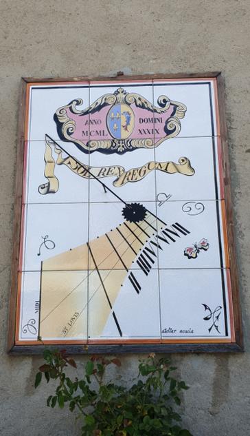 Relógio de sol fixado em uma parede externa. Texto: Anno MCML, Domini XXXIX. Contém uma faixa com as horas e alguns adornos.
