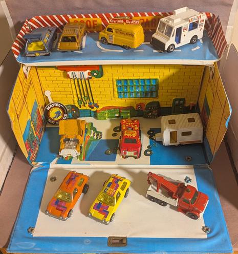 A vintage Matchbox Sears service center playset with several vintage diecast cars from different eras.