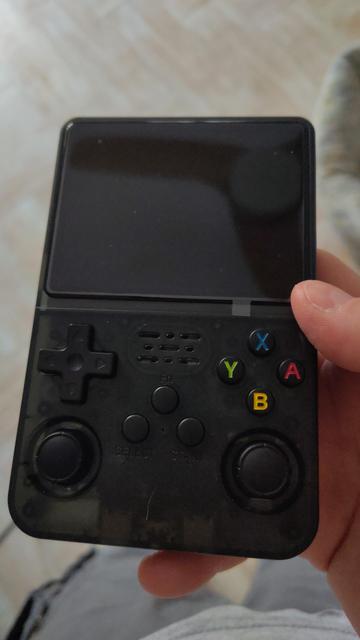 A photo of black variant of the R36S which generally looks like Gameboy but with two analog sticks at the bottom.