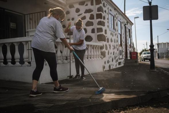 Personas barriendo ceniza del volcán en El Paso, La Palma. (Anadolu Agency via Getty Images)
