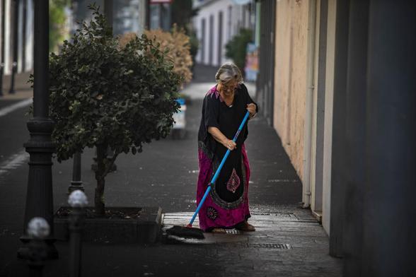 Una señora barriendo la ceniza que desprendió la erupción del volcán en septiembre de 2021. (Europa Press via Getty Images)