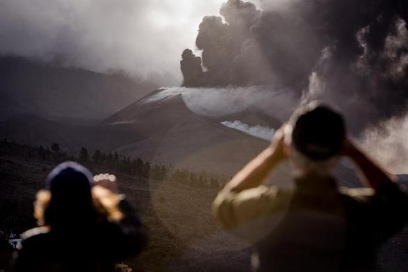 Volcán de La Palma en erupción siendo fotografiado por dos personas. (Anadolu Agency via Getty Images)