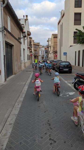 Xiquetes i xiquets anant en bici a l'escola