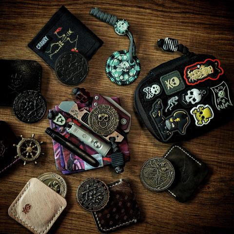 photograph of some pirate themed EDC, lots of pirate coins