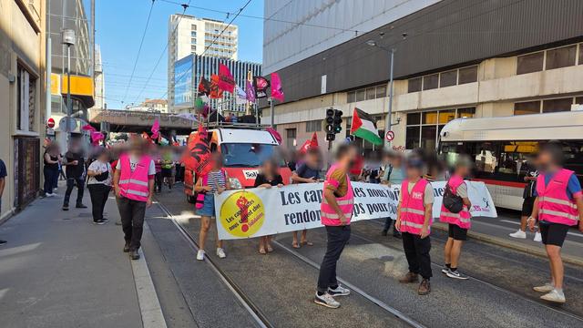 Photo de la tête du cortège de la manifestation qui a eu lieu ce vendredi 19 septembre à Lyon, suite à l'appel à la grève reconductible par Solidaires Rhône. On y voit la banderole Solidaires, suivi du camion Solidaires orné des drapeaux de tous les syndicats de Solidaires Rhône et d'un drapeau de la Palestine, ainsi que des syndicalistes en chasubles roses Solidaires et des manifestant·es.