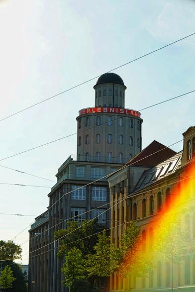Turm hinter Straßenbahnen-Leitungs-Spinnennetz
Heftiger flare in der rechten/unteren Ecke.