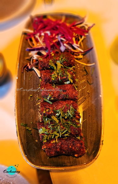 Plate of sizzling lamb seekh kebabs garnished with fresh coriander and served with crisp red cabbage salad at Jasmine Indian Restaurant in Milton Keynes. Captured by UK blogger Anamika Chattopadhyaya for her Everything Enchanting blog and SM pages.