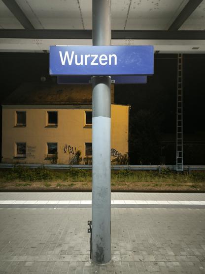 Bild zeigt den Bahnhof von Wurzen mit dem blauen Stationsschild.
