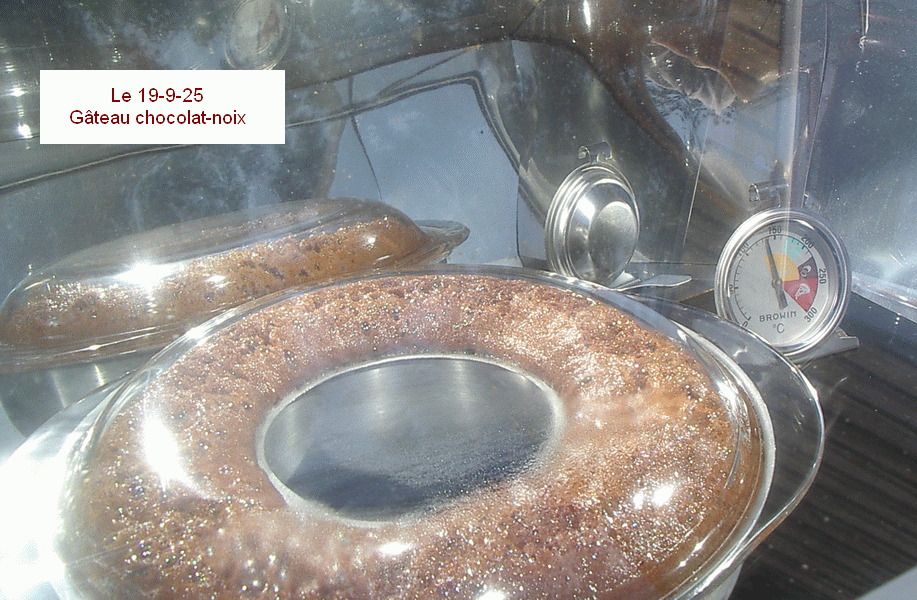 A l'intérieur d'un four solaire, cuit un gâteau déjà bien gonflé dans un moule en couronne métallique avec couvercle en verre. Le thermomètre indique à peine 140°.