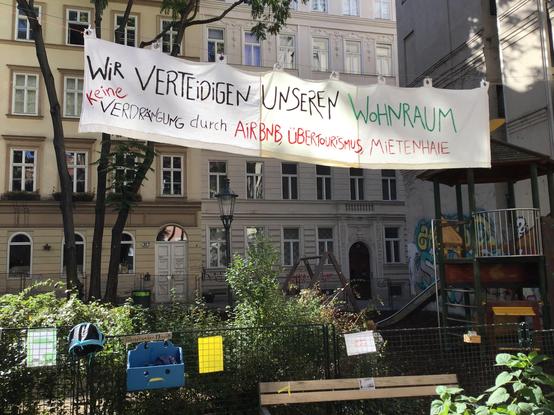 Auf einem Banner steht „Wir verteidigen unseren Wohnraum. Keine Verdrängung durch Airbnb,  Übertourismus, Mietenhaie”