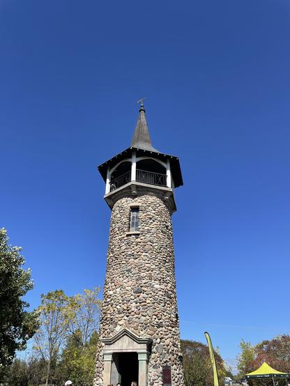 Pioneer Tower, a tower with stones on the exterior, windows and a weather vane that is a covered wagon.