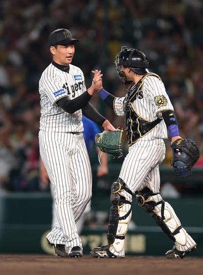 阪神対DeNA DeNAに勝利し、タッチを交わす阪神岩崎（左）と梅野（撮影・前田充）