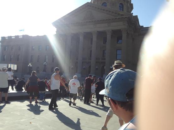 An attempt at photographing a protest with the sun in the camera man's eyes. 

The building in the background is the Alberta Legislature building, currently the royal court of her imperial majesty, Danielle Smith.