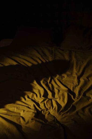 shadow of person on bed shee