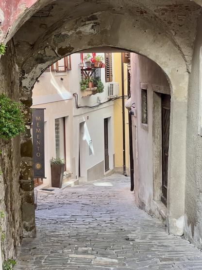 Kleine Gasse mit Torbogen in einem Haus im Vordergrund