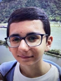 Das Bild zeigt ein junges männliches Gesicht mit dunklem Haar und Brille, das direkt in die Kamera blickt. Der Hintergrund zeigt eine natürliche Landschaft mit einem ruhigen Fluss und bewaldeten Hügeln. Der Junge trägt ein weißes T-Shirt und einen blauen Pullover, der über der Schulter hängt. Sein Gesichtsausdruck ist freundlich und entspannt. Die Umgebung deutet auf eine ruhige, natürliche Umgebung hin, möglicherweise in einem Berggebiet.

Bereitgestellt von @altbot, privat und lokal generiert mit Ovis2-8B