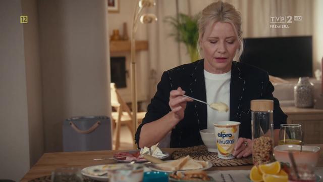 Natalia Boska (Małgorzata Kożuchowska) zajada się jogurtem "prawie jak Skyr" Alpro o smaku mango podczas śniadania.