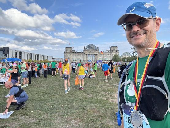 Ein Selfie von mir mit Medaille auf der Wiese vor dem Reichstag, zusammen mit vielen anderen Läufern