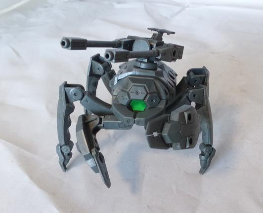 An insectile bug robot with a green sensor eye, claws, and twin guns on its back. Front view.