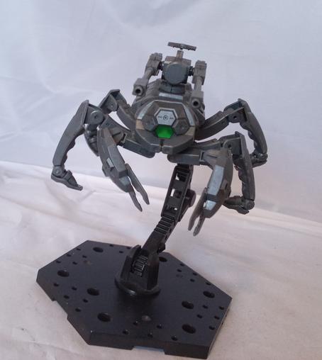 An insectile bug robot with a green sensor eye, claws, and twin guns on its back. Front view, on a flight base.