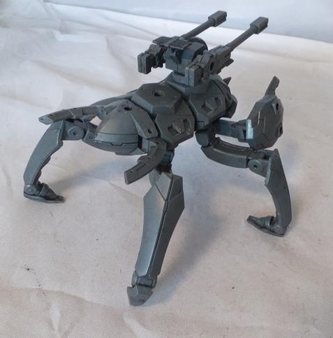 An insectile bug robot with a green sensor eye, claws, and twin guns on its back. Rear view, with a focus on the tail forceps.