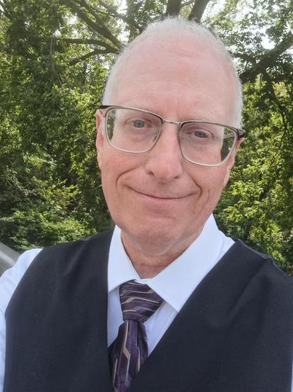 Me, in my professional magic vest and tie. My background is green trees.