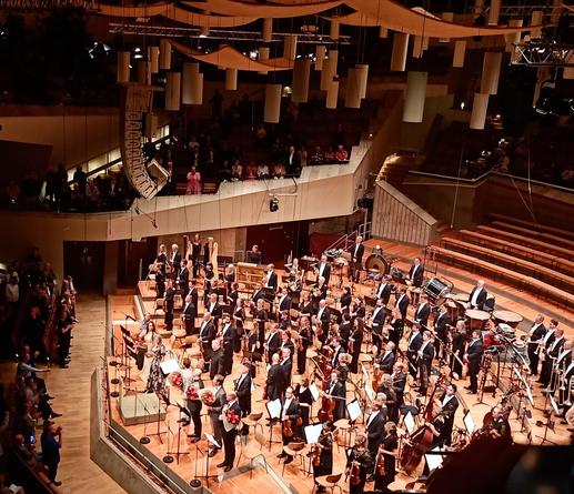 Sänger:innen, Dirigent und Orchester verbeugen sich