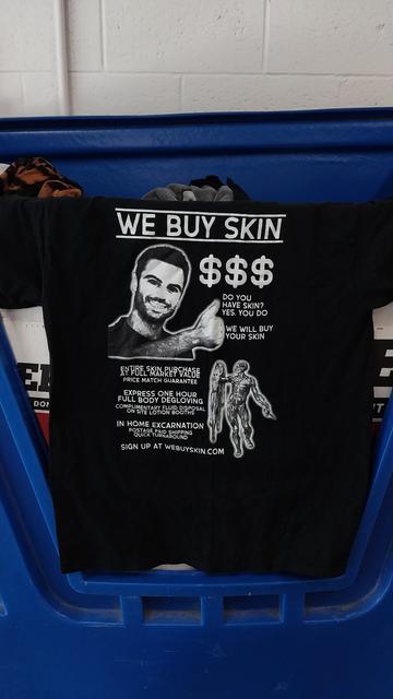 T-shirt that says "WE BUY SKIN - Do you have skin? Yes, you do - We will buy your skin - Entire skin purchase at full market value - Express one hour full-body degloving - In-home excarnation - Sign up at webuyskin.com"
