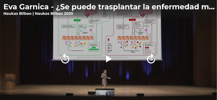 imaxe capturada do vídeo da charla ca divulgadora Eva Garnica no escenario diante da pantalla onde se proxecta a sua presentación