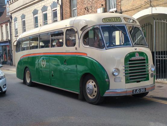 A beautiful cream-over-green Bedford coach, queuing outside 18th century shops in Downham Market High Street. New in 1952, it has none of the chrome of later years, but a much curvier cuddly shape. The windscreen - made from four separate pieces of glass - curves around the front for better visibility.