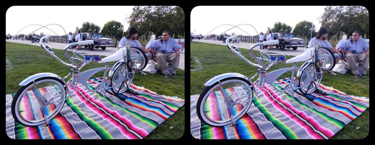 A shiny chrome and grey lowrider style bicycle.