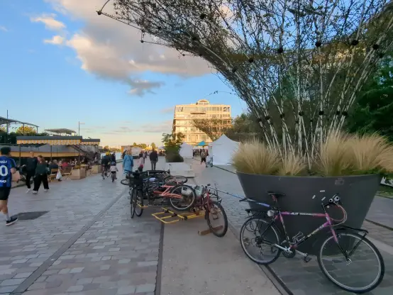Place de la pointe à Pantin avec 2 vélos tirant chacun une cariole transportant d'autres vélos