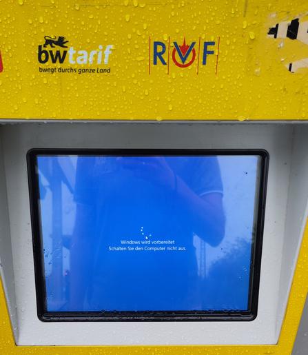 Ein Fahrkartenautomat der deutschen Bahn zeigt einen Bluescreen mit Text: "Windows wird vorbereitet. Schalten Sie dem Computer nicht aus."