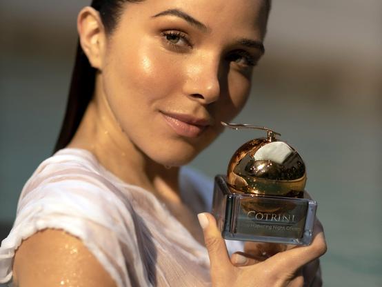 Model holding up a jar of Cotrini night cream.
