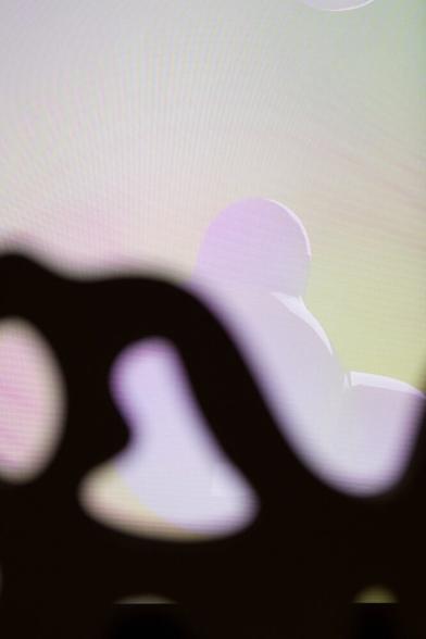 un écran montre des formes colorées  en forme de bulles deriière une structure de bois