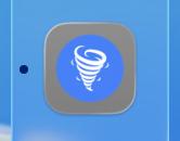 An icon of a white tornado in a blue circle, now set on a generic gray roundrect by macOS Tahoe.