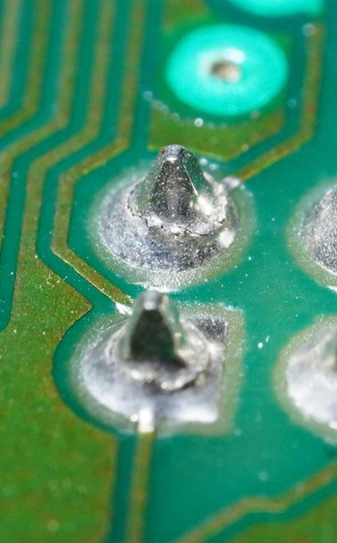 Macroaufnahme von zwei lötstellen, die sehr gut sichtbare risse im metall aufweisen